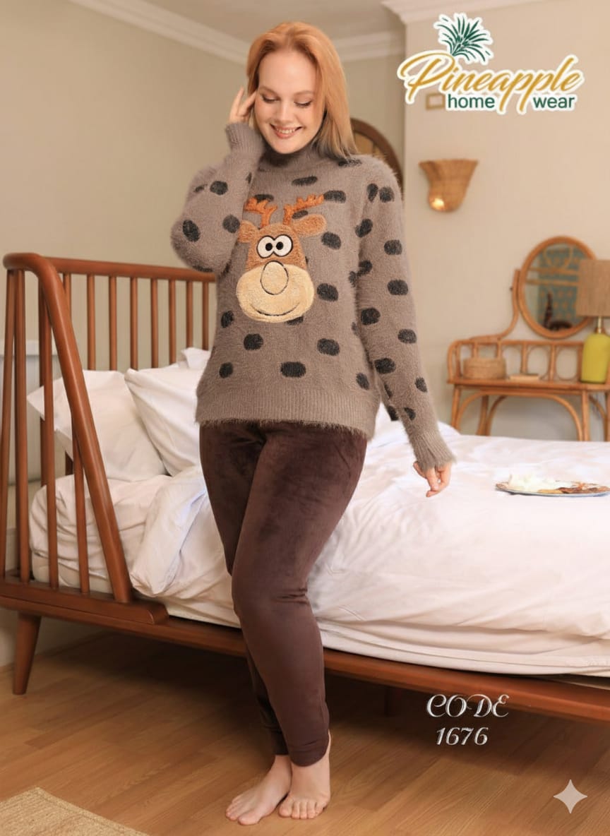 Woman wearing a patterned sweater with a reindeer design in a bedroom setting, Pineapple Home Wear brand visible.