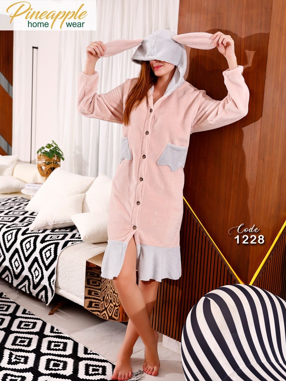 Woman wearing a pink nightgown with a white hat in a bedroom setting, Pineapple Home Wear brand visible.