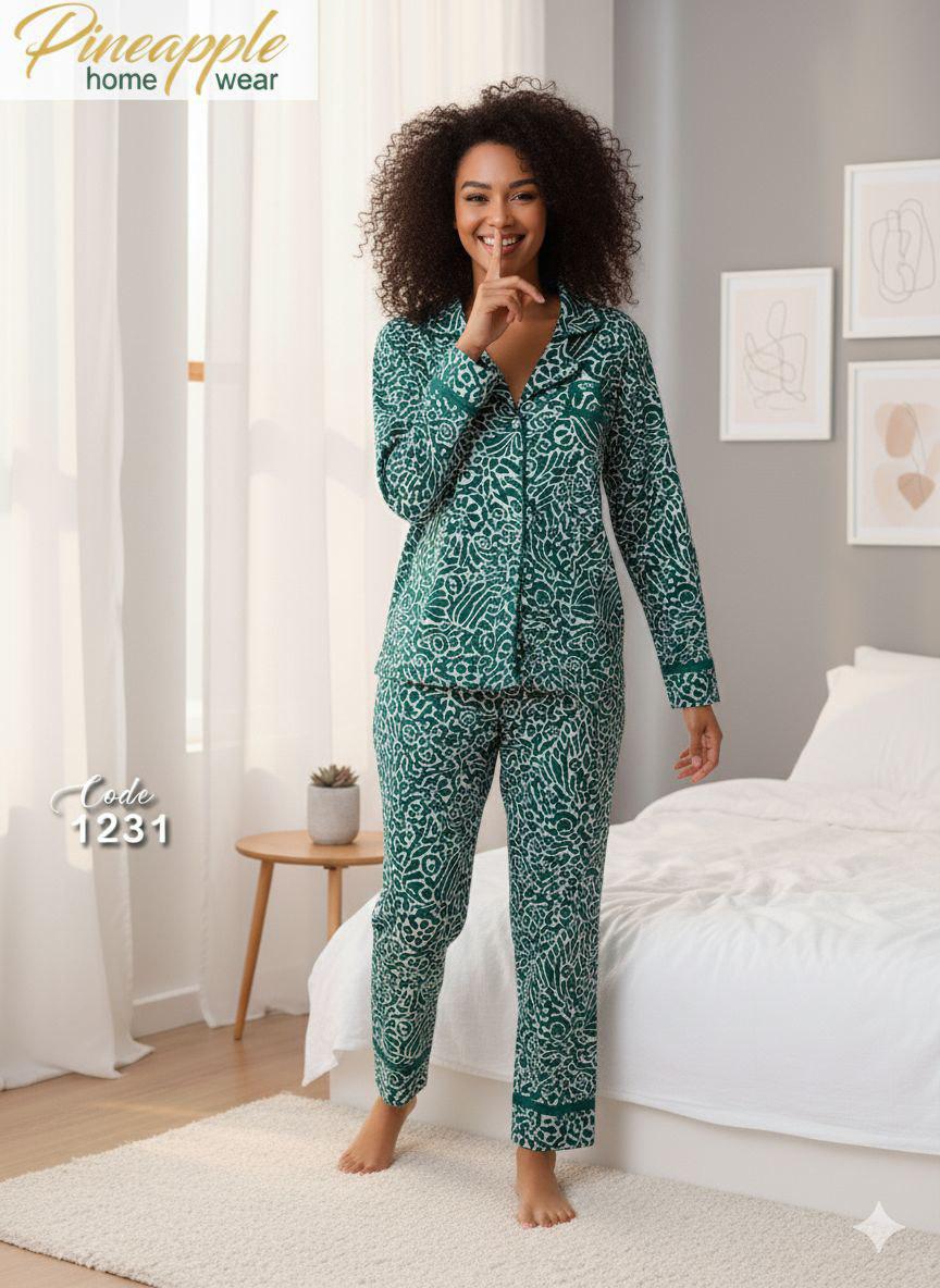 Woman wearing a green patterned pajama set in a bedroom setting.