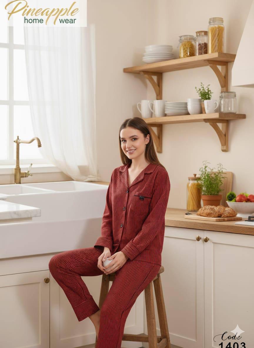 Woman in red pajama set sitting on a stool in a kitchen, with 'Pineapple Home Wear' branding.