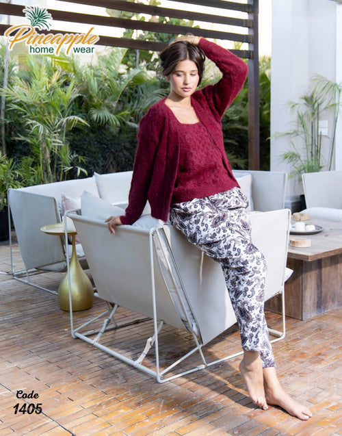 Woman sitting on a modern outdoor chair wearing a maroon sweater and patterned pants, with 'Pineapple Home Wear' branding.