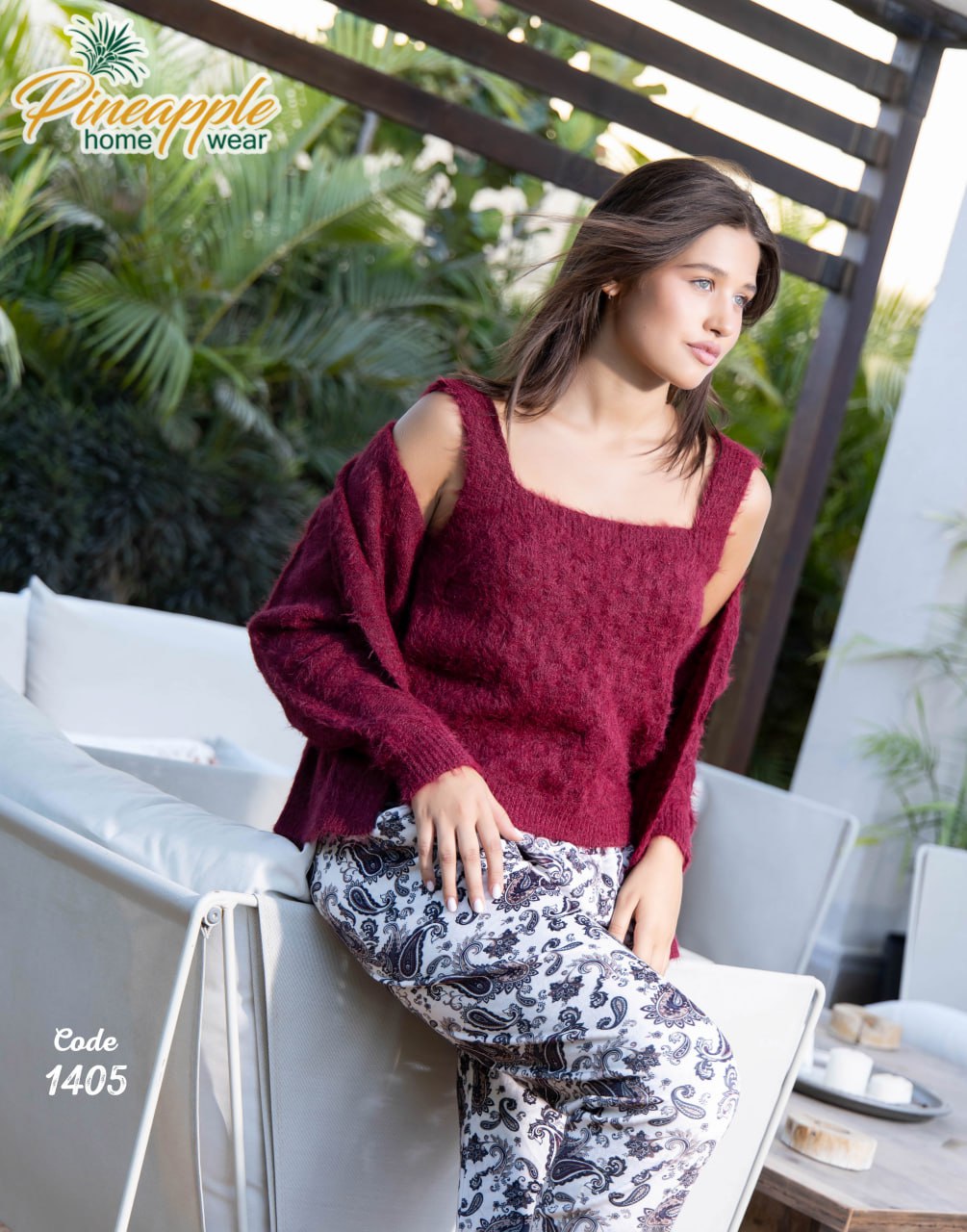Woman wearing a maroon sweater and patterned pants sitting outdoors with 'Pineapple Home Wear' branding.