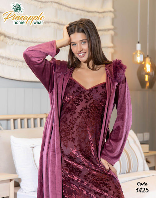 Woman wearing a maroon velvet nightgown with matching robe in a cozy room setting.