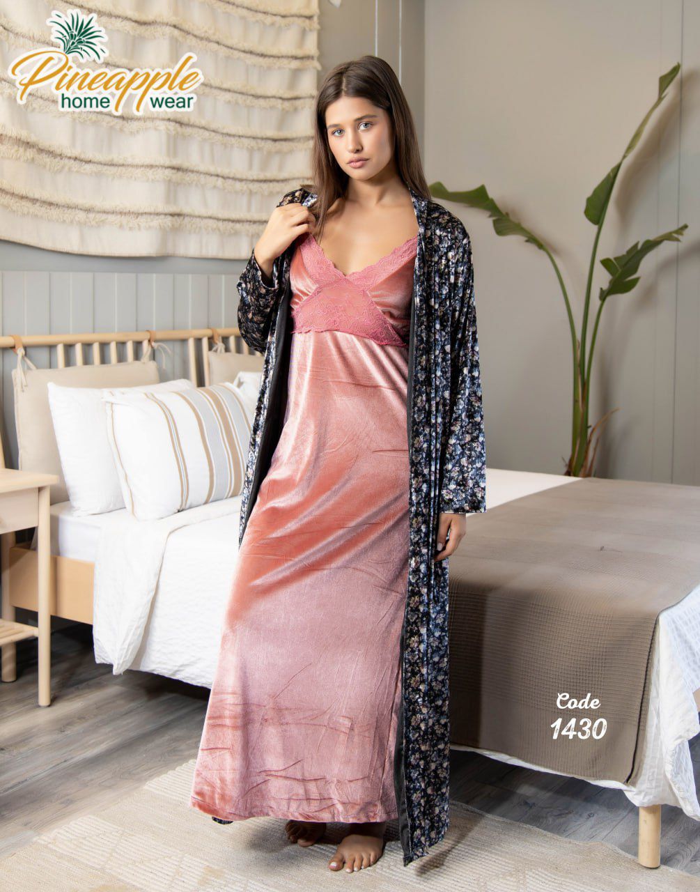 Woman in a pink dress and black floral kimono standing in a bedroom setting with 'Pineapple Home Wear' branding.