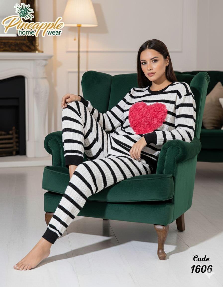 Woman wearing a black and white striped onesie with a pink heart in a living room setting.