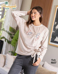 Woman wearing a 'lovely' printed long-sleeve top in a home setting