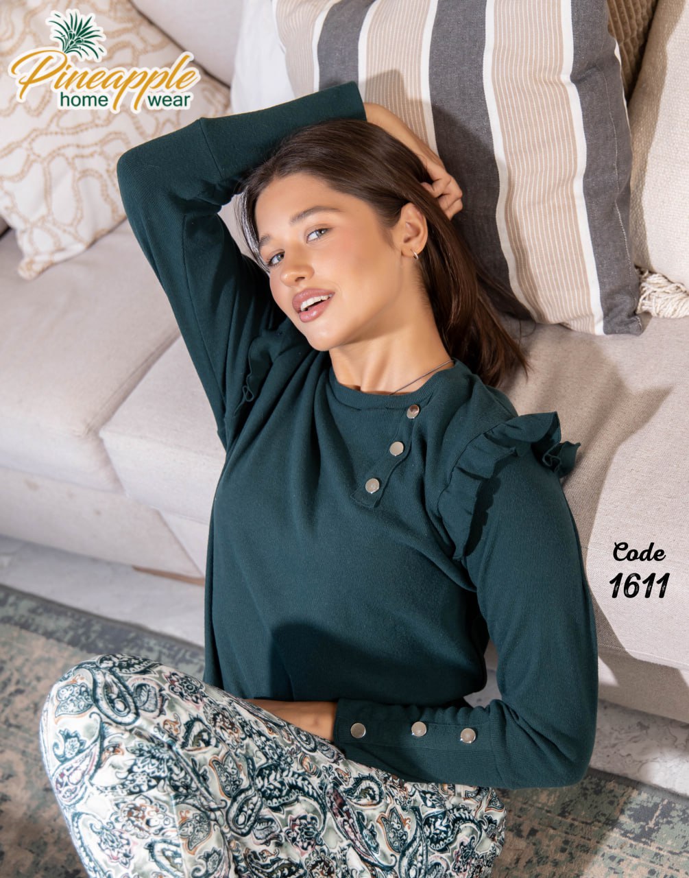 Woman wearing a dark green top and patterned pants lying on a couch with 'Pineapple Home Wear' branding.
