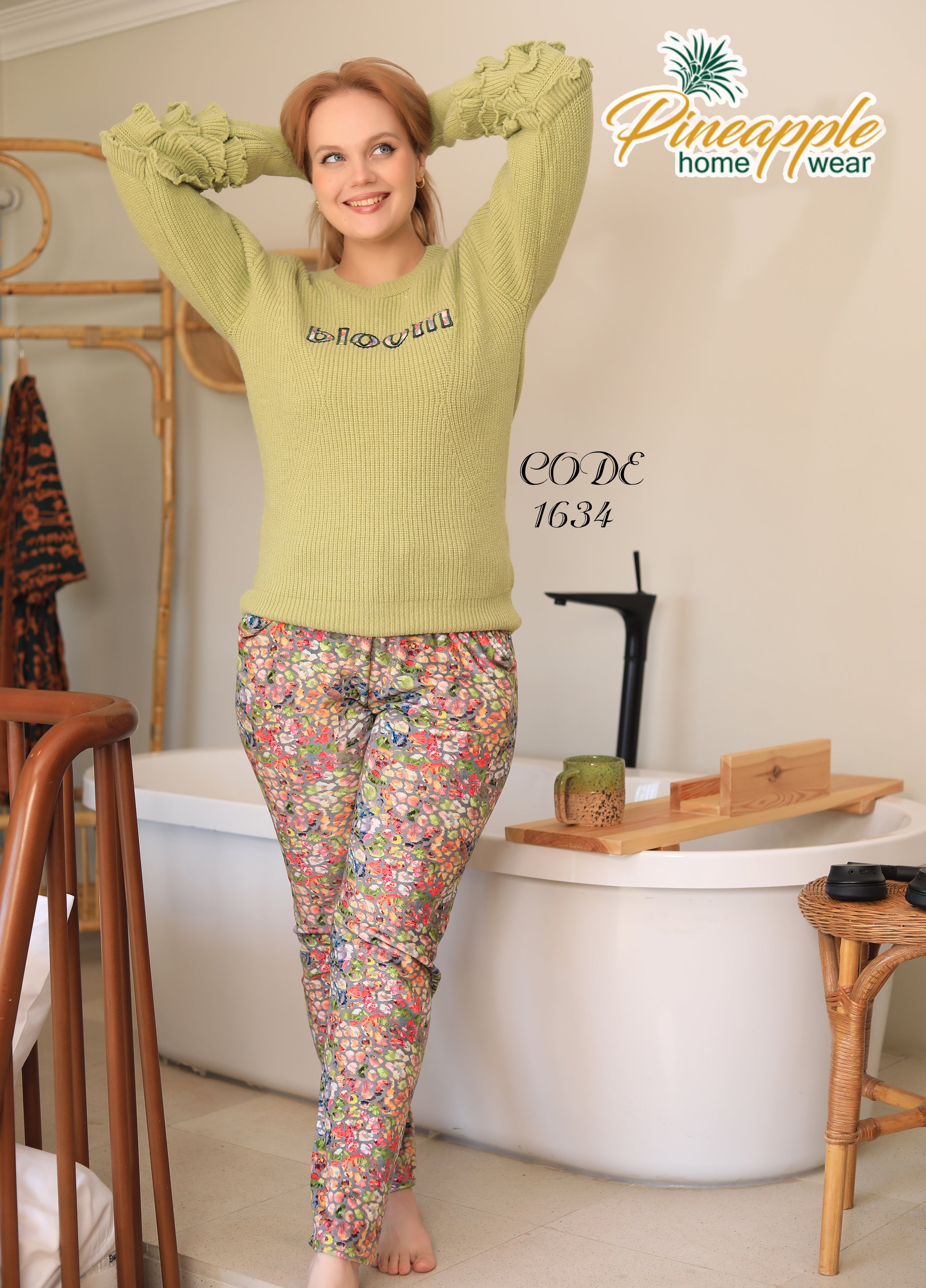 Woman wearing a green sweater and floral pants in a bathroom, with 'Pineapple Home Wear' branding.