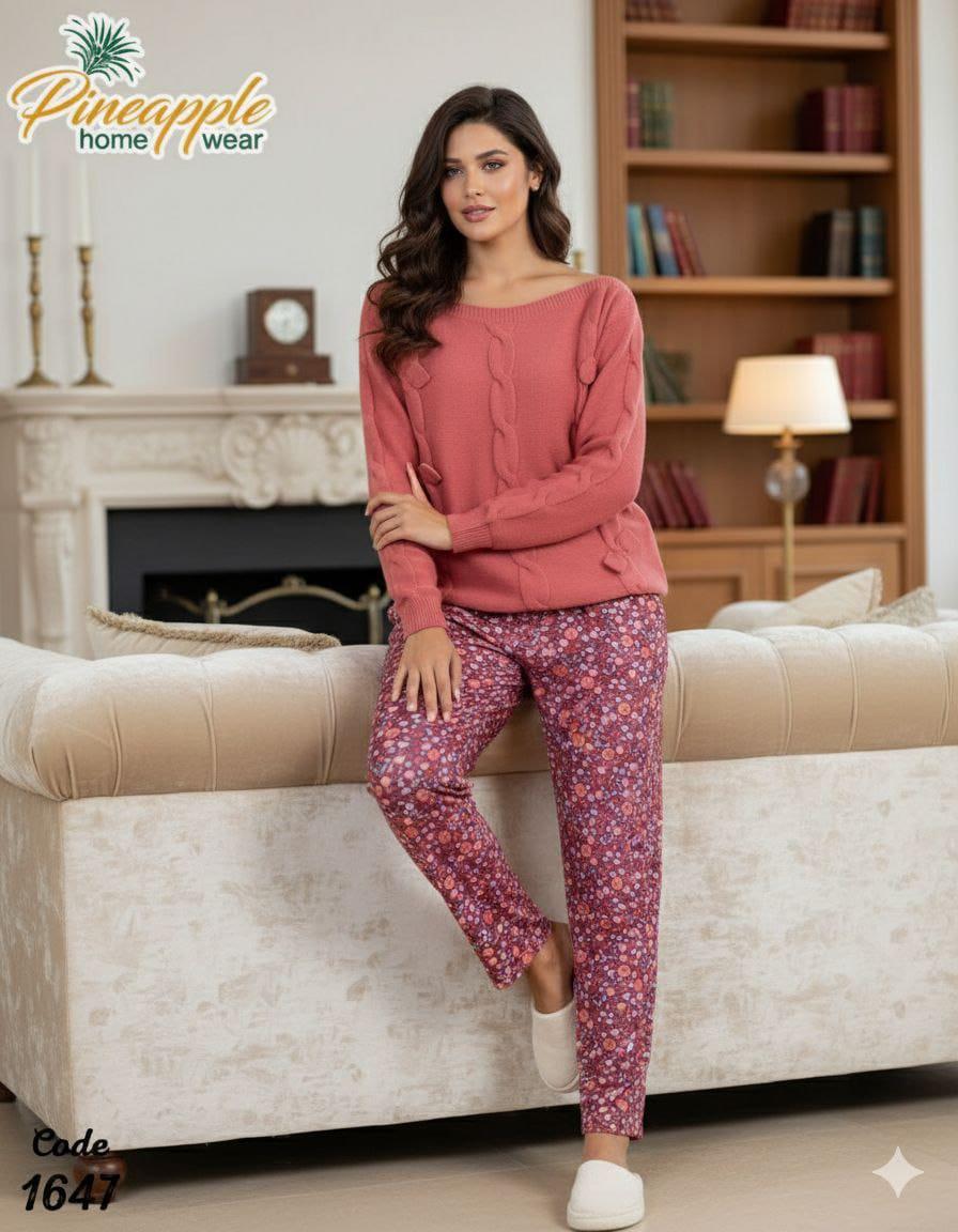 Woman wearing pink pajama set sitting on a couch in a cozy living room with 'Pineapple Home Wear' branding.