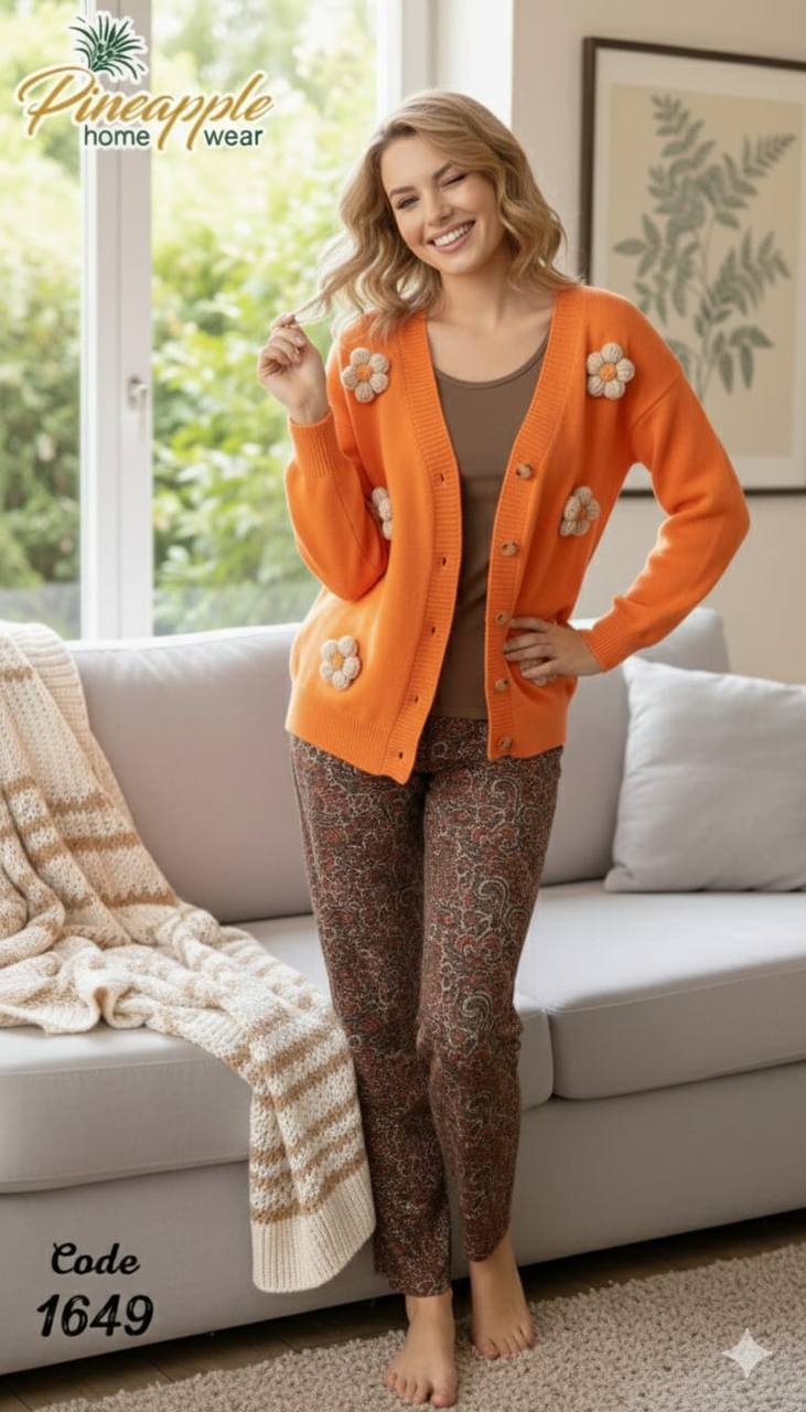 Woman wearing an orange cardigan with floral embellishments in a living room setting.