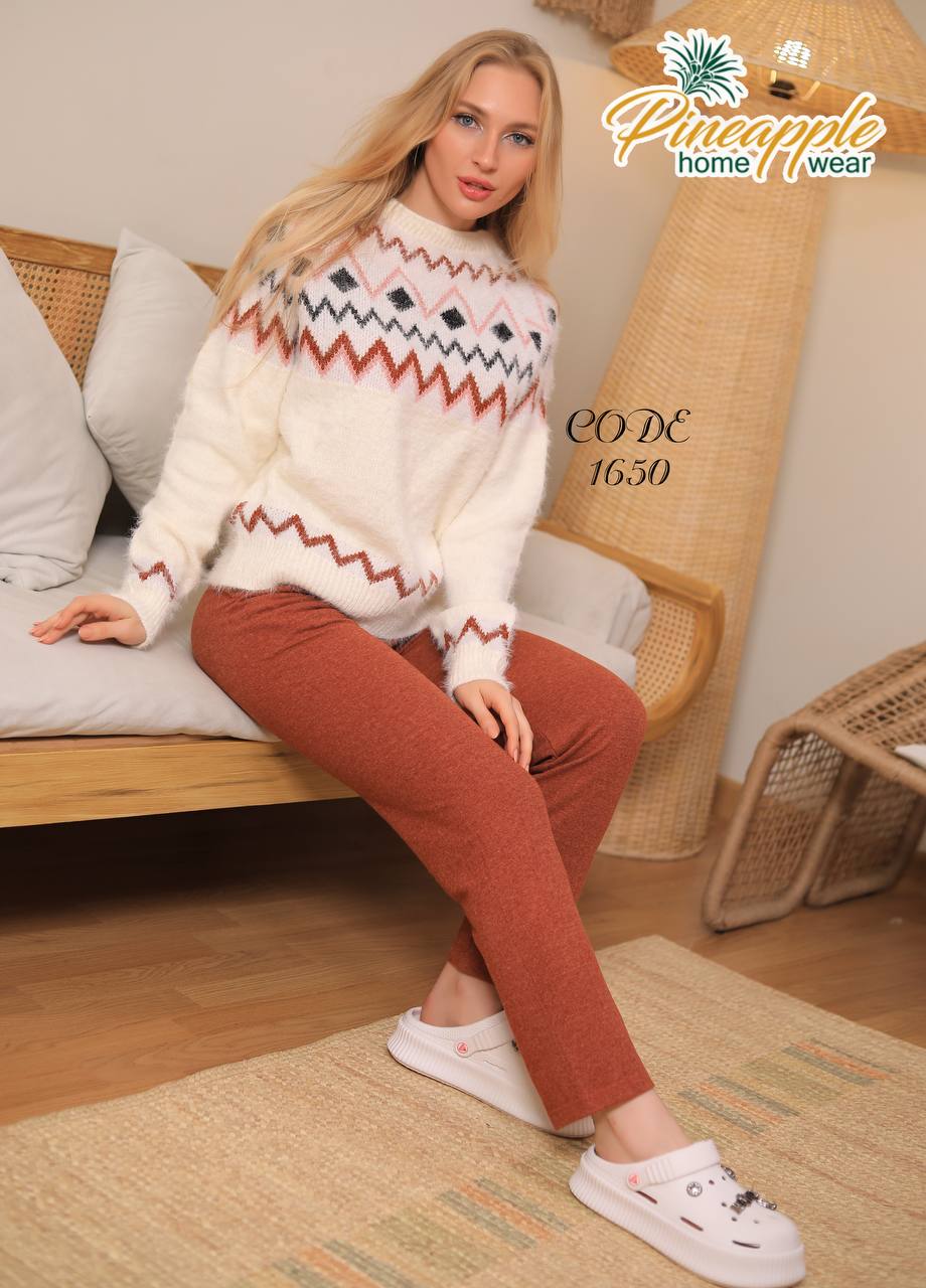 Woman wearing a patterned sweater and red pants sitting on a couch with 'Pineapple Home Wear' branding.