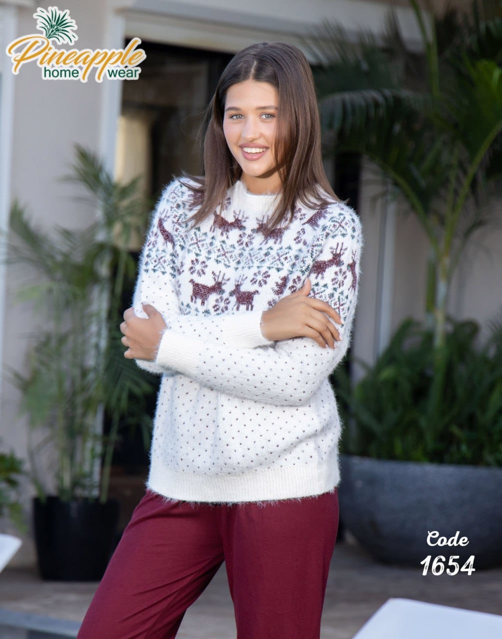 Woman wearing a patterned sweater with reindeer design outdoors, with 'Pineapple Home Wear' branding.