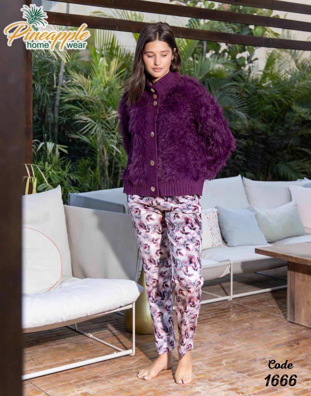 Woman wearing a purple cardigan and patterned pants standing in an outdoor setting with 'Pineapple Home Wear' branding.