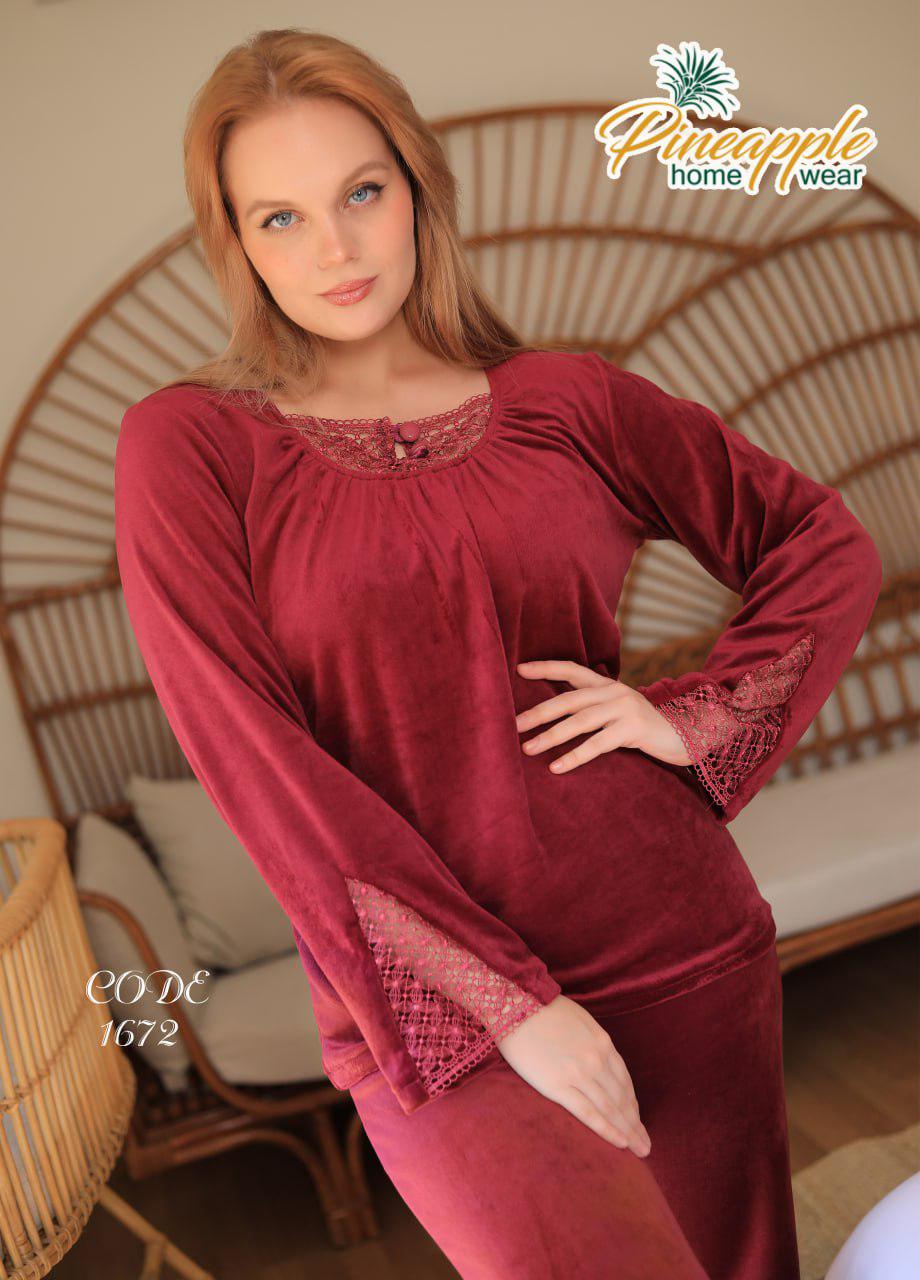 Woman wearing a burgundy nightgown with lace details in a home setting, branded 'Pineapple Home Wear'.