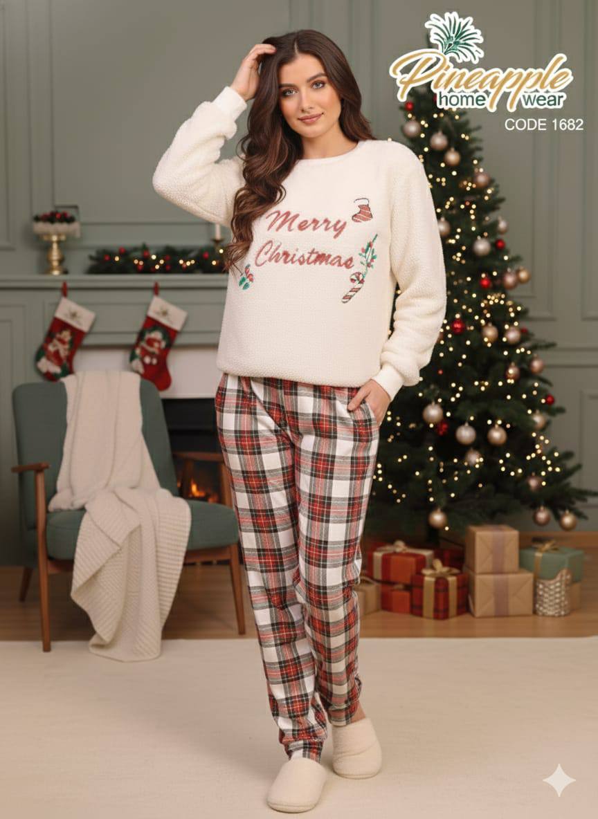 Woman wearing a Christmas-themed sweater and plaid pants in a festive living room.