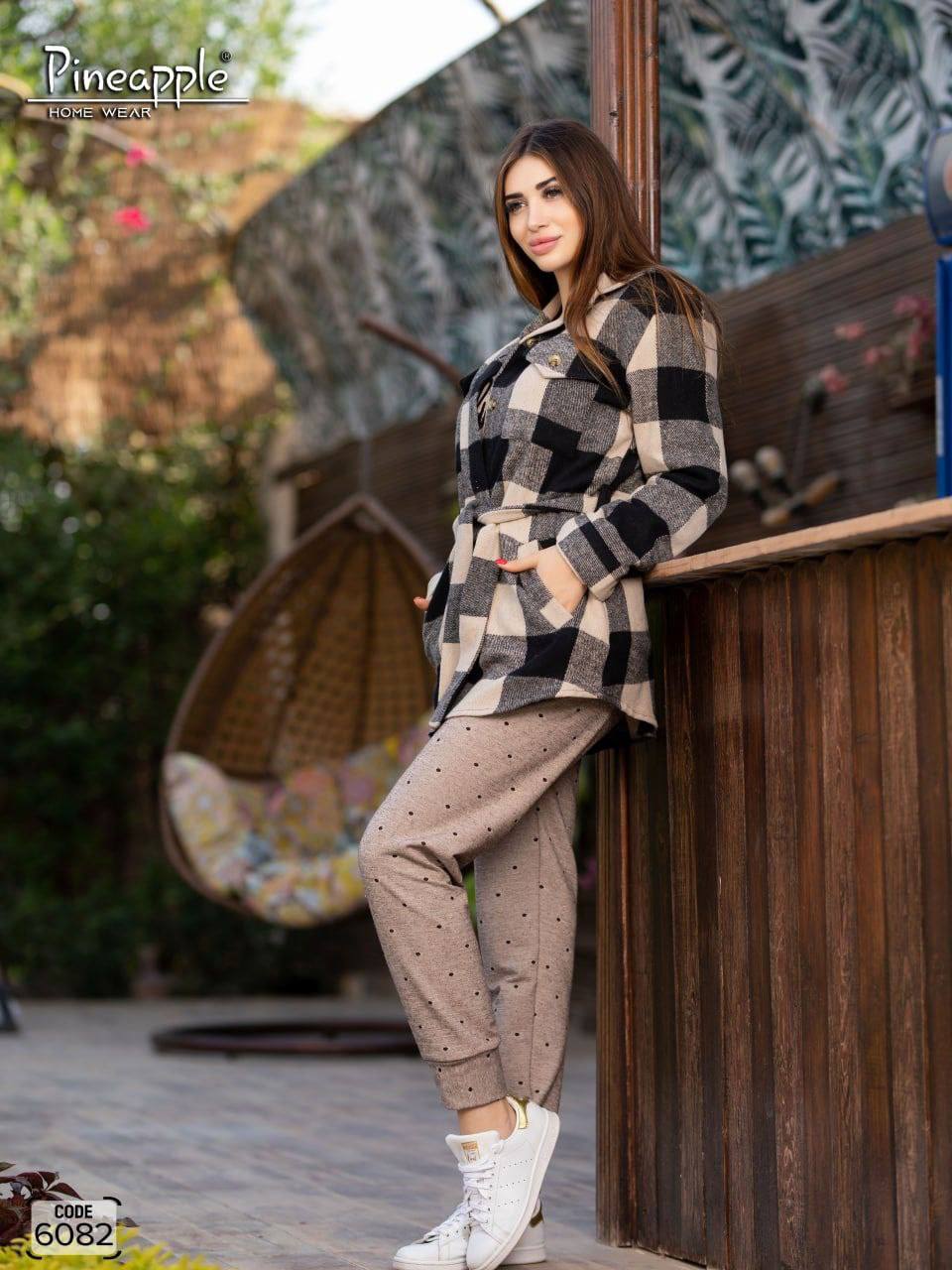Woman wearing a checkered coat and beige outfit, with 'Pineapple Home Wear' branding.
