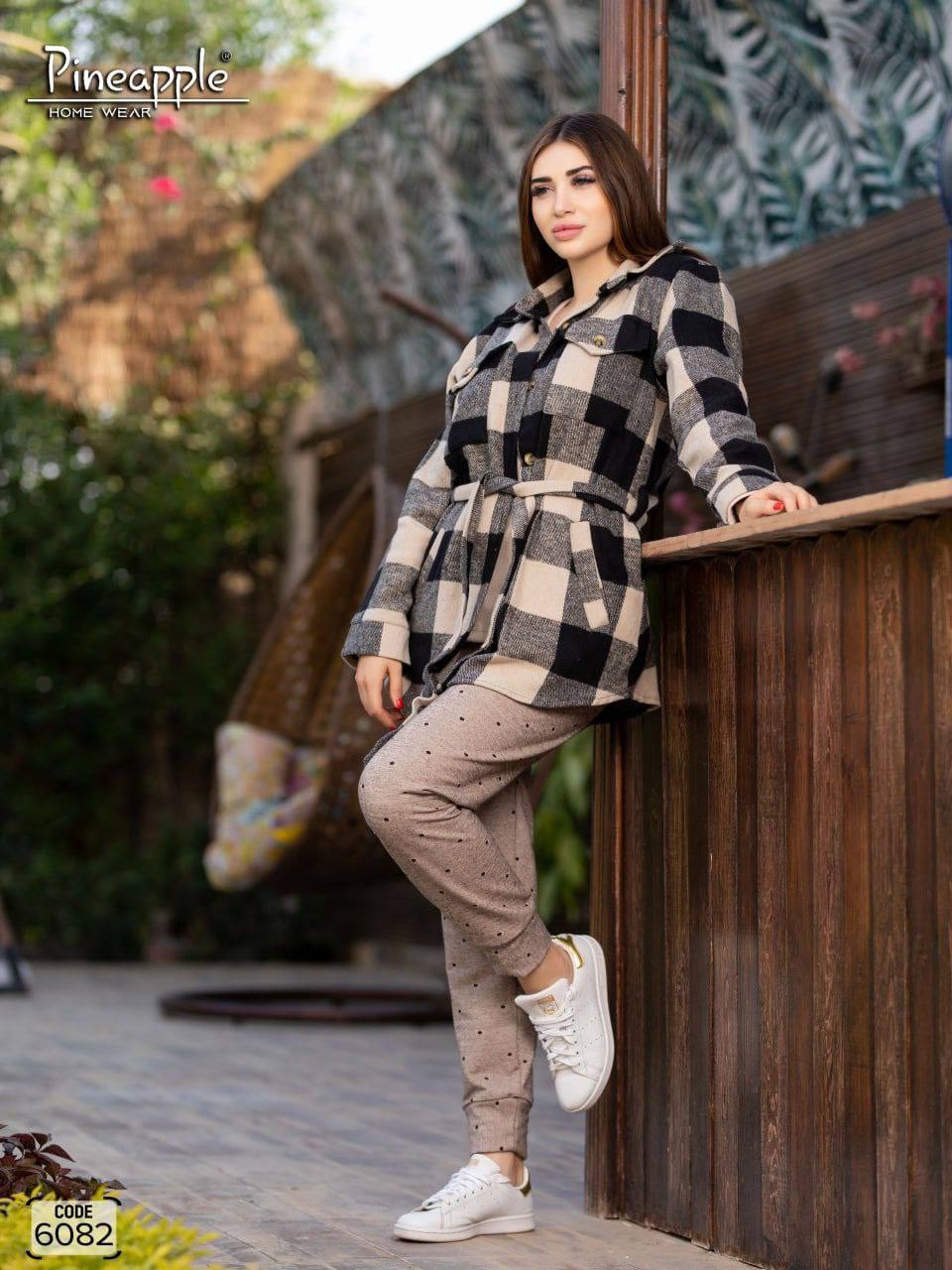 Woman wearing a checkered coat and beige outfit, with 'Pineapple Home Wear' branding.