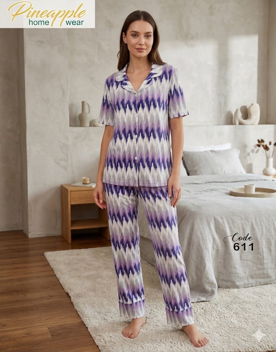 Woman wearing a purple and white zigzag pattern pajama set in a bedroom setting.