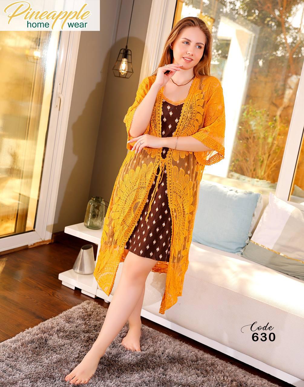 Woman in a yellow kimono-style garment sitting on a couch in a home setting.