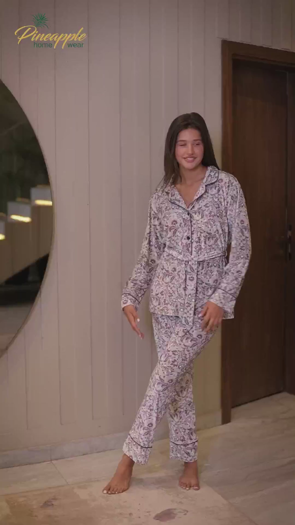 Woman wearing a floral pajama set with 'Pineapple Home Wear' branding.